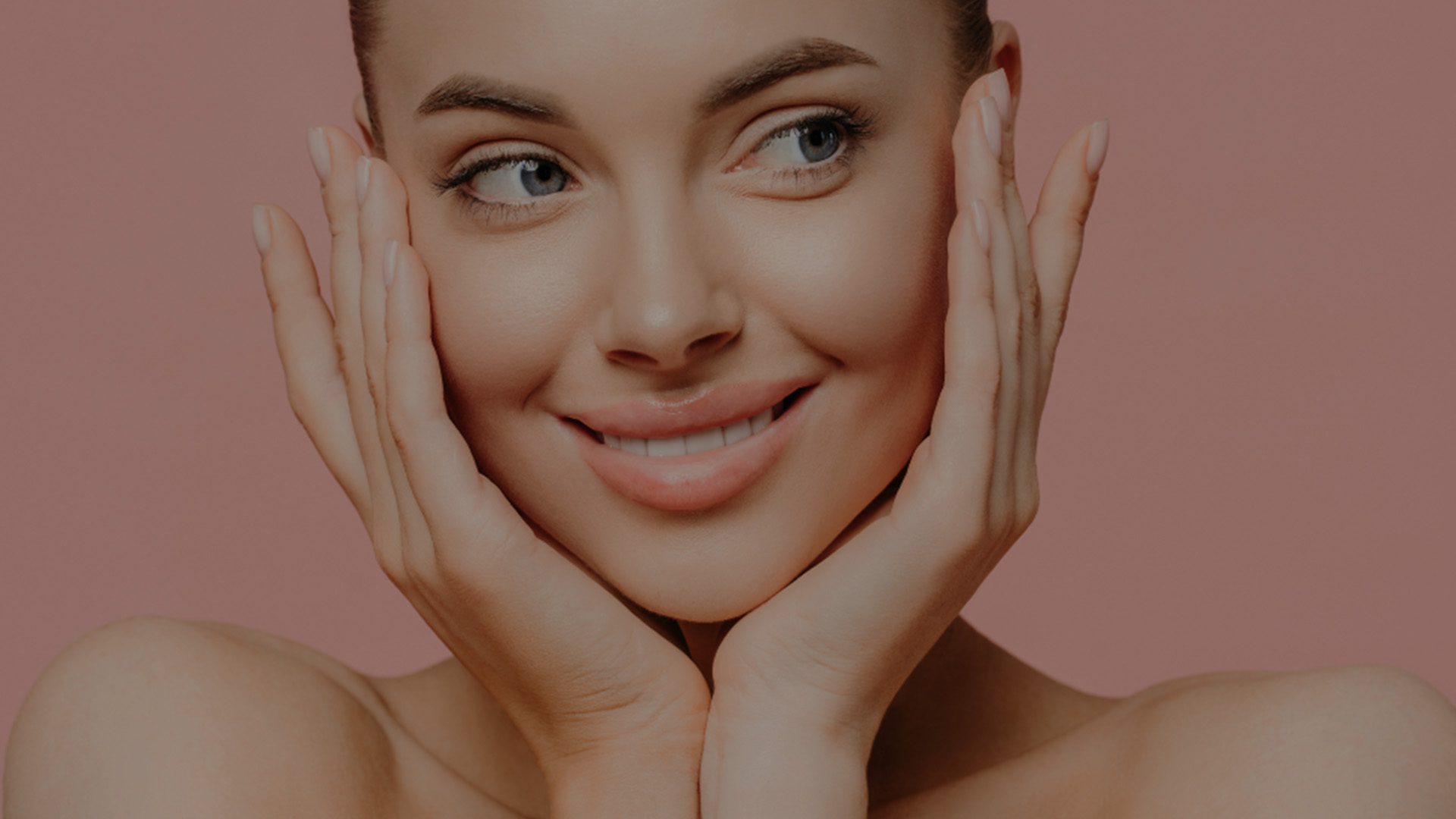 The image shows a woman with her hands placed on her cheeks, looking directly at the camera with a neutral expression.