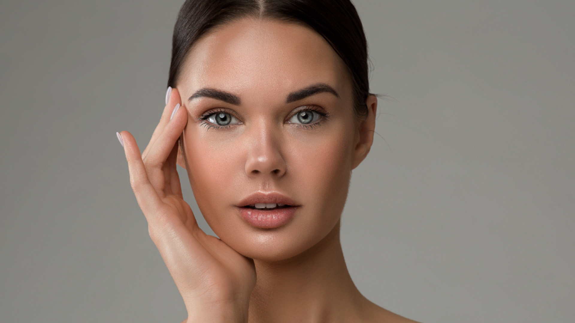 A woman with makeup on her face, looking directly at the camera, with a focus on her eyes and facial expression.