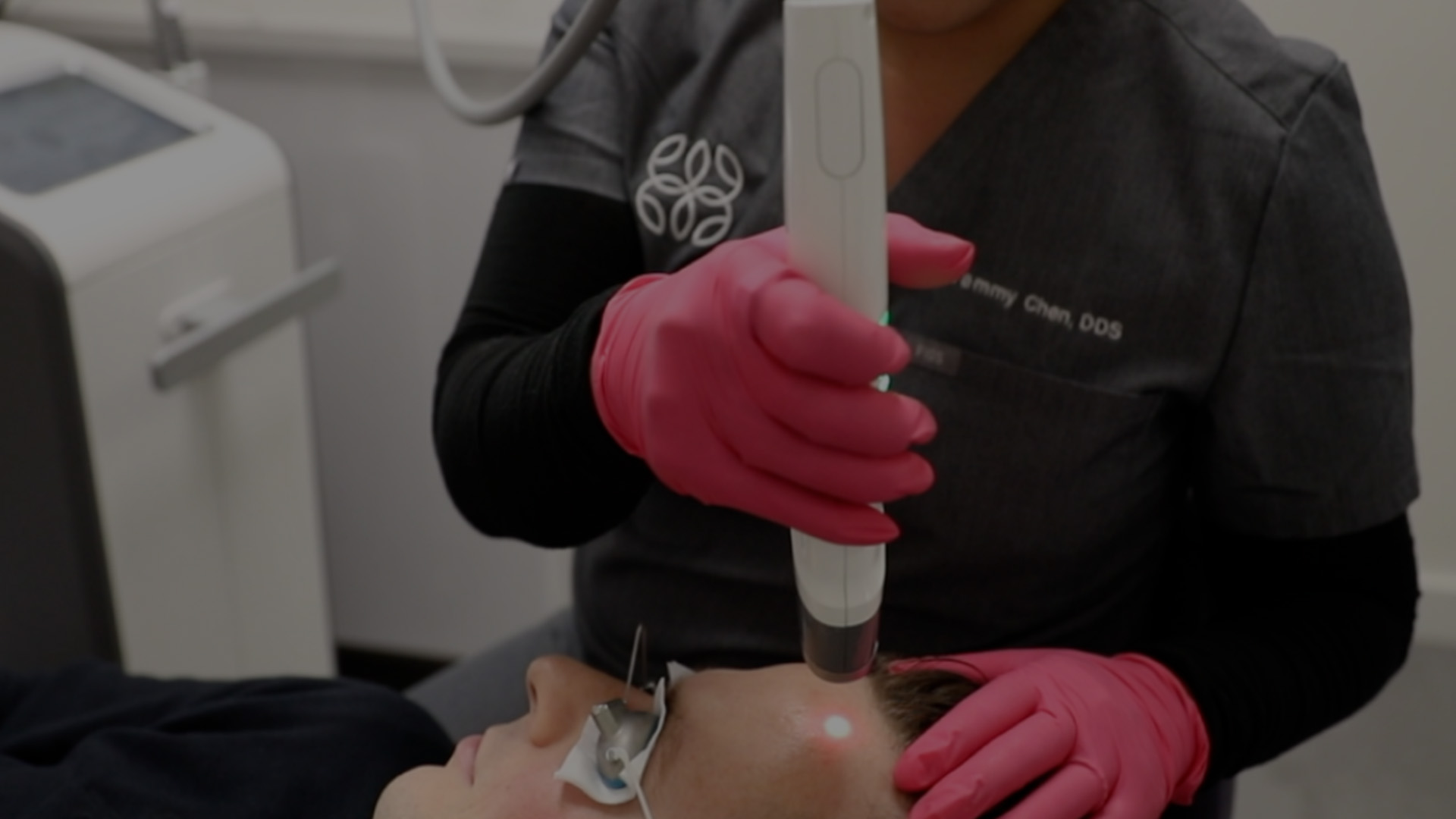 A person receiving dental treatment with a dental hygienist using an ultrasonic scaler.