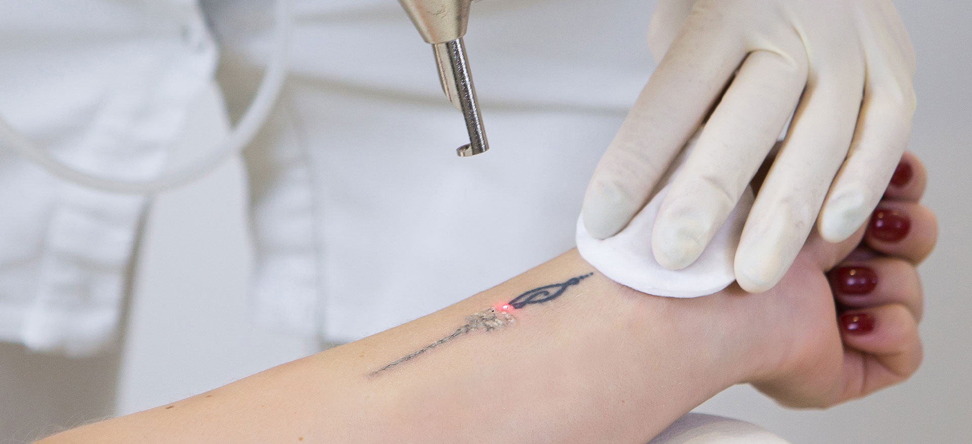 A tattoo artist applying ink to a client s skin using a tattoo machine.