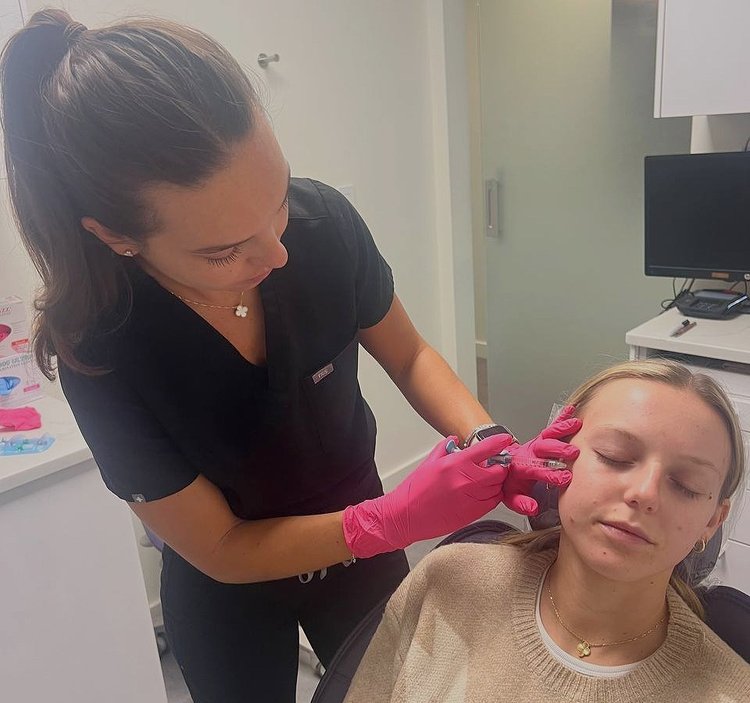 A woman receiving beauty treatment from another woman who appears to be a professional.