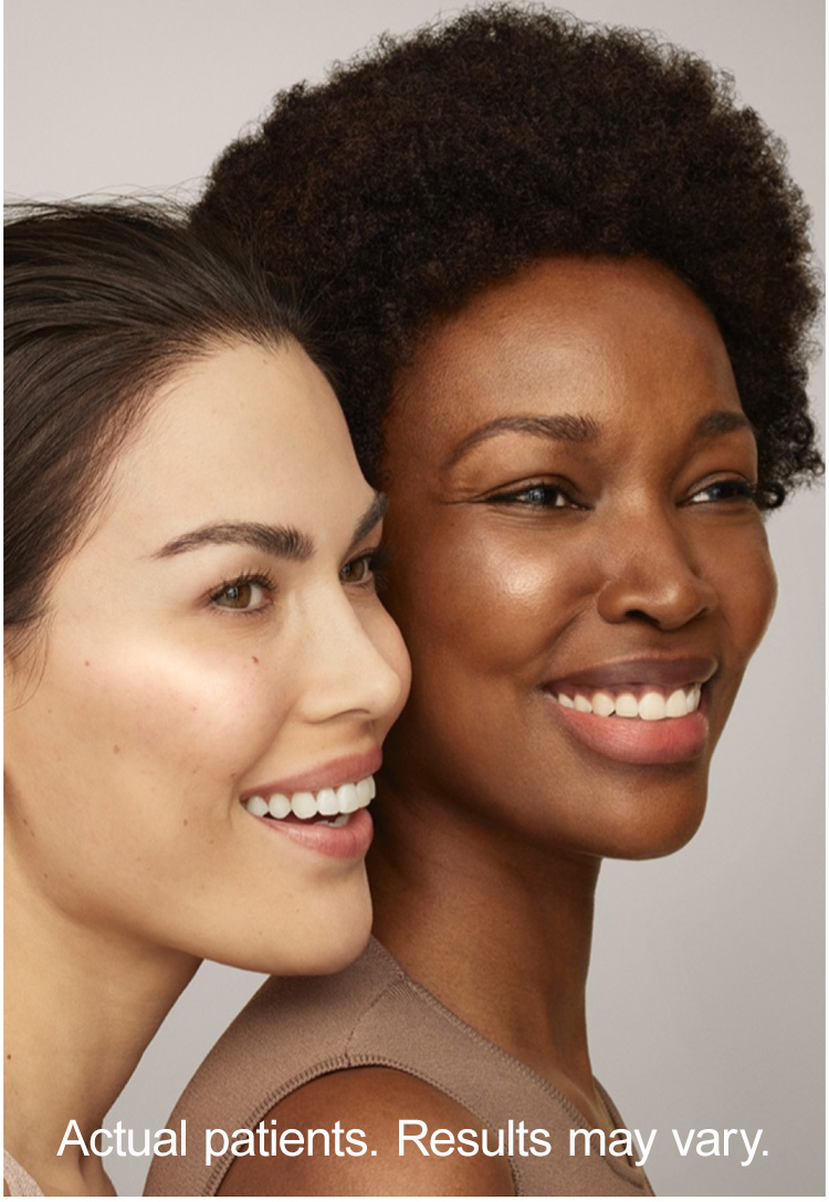 The image shows two individuals, likely models, posing closely together with smiles  they are positioned against a neutral background with a watermark text overlay.